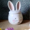 Brûle parfum en céramique en forme de lapin avec bougie décorative en forme d'œuf jaune motif fleur, ambiance printanière.