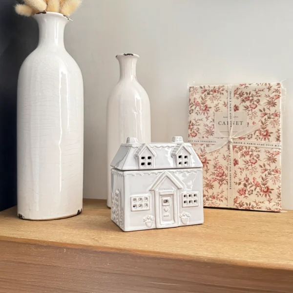 Brûle-parfum en céramique blanche en forme de cottage, élément décoratif raffiné pour une ambiance chaleureuse et parfumée.