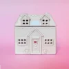 Brûle-parfum en céramique en forme de maison cottage, vue de face, avec des détails sculptés, fenêtres et porte ajourées.