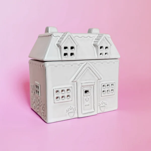 Brûle-parfum en céramique Cottage, vue de trois-quarts, avec un design en forme de maison décorative et détails sculptés.