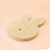 Support en bois naturel en forme de lapin allongé avec petit cœur gravé, idéal pour bougies décoratives, fondants parfumés ou accessoires déco, sur fond pastel.