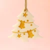 Suspension parfumée Pimp My Tree en forme de sapin, décorée de détails dorés, parfum sapin de Noël, présentée sur fond rose pastel.